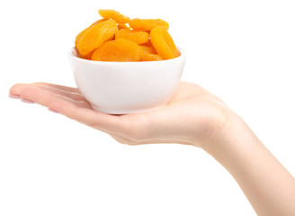 Dried apricots in bowl in hand on white background isolation