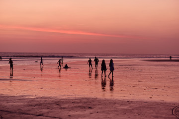 Fototapeta na wymiar People walking on the Kuta Beach Bali, Indonesia, during sunset and low tide