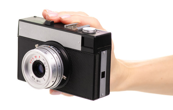 Old photo camera in hand on white background isolation