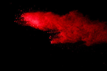 Naklejka na ściany i meble abstract red powder explosion on black background.abstract red powder splatted on black background. Freeze motion of red powder exploding.