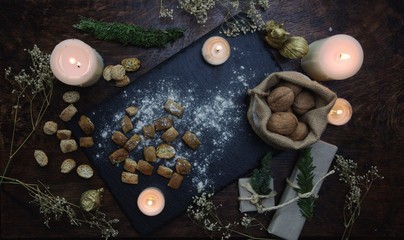 Yule winter solstice (Christmas) kitchen witchery. Preparation of festive food on dark wooden...