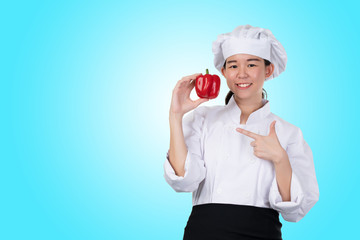 Asian women chef wearing white suit with clean hat Hand holding large Bell pepper with quality. It is useful to cook people to eat, such as antioxidants. It helps to prevent reduce the risk of cancer.