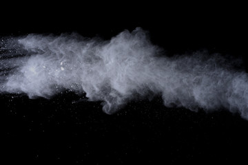 White powder explosion on black background. Colored cloud. Colorful dust explode. Paint Holi.