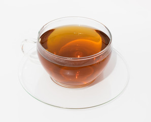 Glass cup of hot brown tea on light background