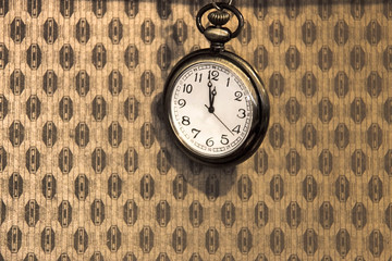 Old pocket watch on retro style background.