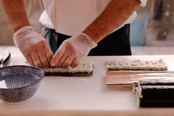 ITAMAE ELABORATING SUSHI MAKI WITH NORI SEAWED AND MAKISU