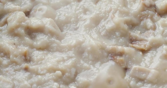 Close video of fish chowder in a pan bubbling and steaming while cooking.