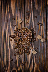 Top view of roasted coffee beans, cane sugar and anise stars on wooden background