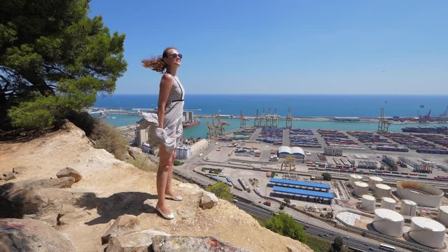Woman in flapping flying dress on mountain top, Barcelona