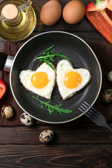 Breakfast: fried eggs with greens in a skillet