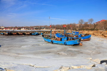 Fototapeta na wymiar Wooden fishing boat on the shores of an icy bay