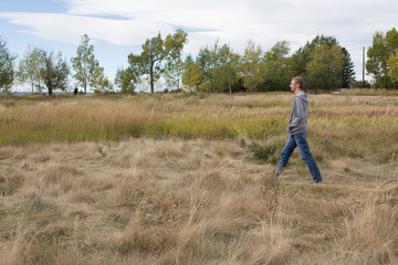 Naklejka na ściany i meble Man walking in a field