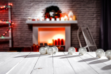 A winter composition on a wooden table in the glow of a fireplace and a Christmas tree decoration on a magical evening   