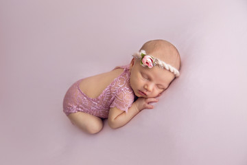 newborn child. little girl. newborn on a pink blanket. the first photo shoot. girl in a bandage...