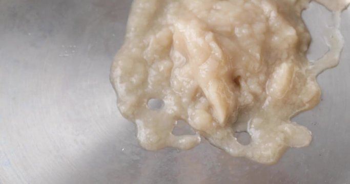 Close video of pouring canned fish chowder into a pan for cooking.