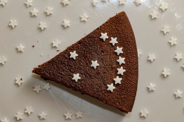 Fetta di torta al cioccolato con stelle di zucchero che formano una faccia sorridente