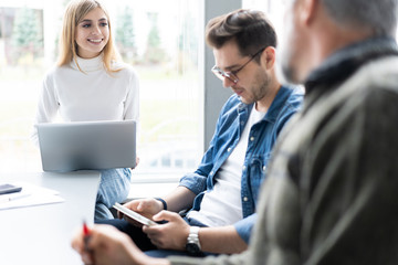 Obraz premium Sharing opinions. Group of young modern people in smart casual wear discussing business while working in the creative office.