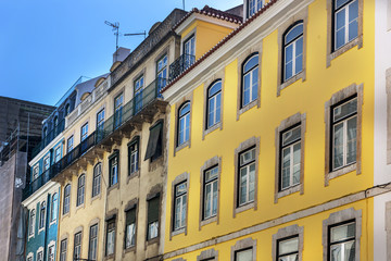 A traditional old building in Lisbon downtown with different colors in a blue sky day