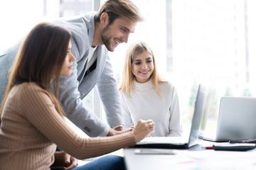 Fototapeta premium Sharing opinions. Group of young modern people in smart casual wear discussing business while working in the creative office.