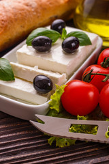A piece of feta cheese on a wooden rustic background