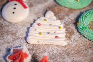 Various Christmas sweet colorful cookies with christmas tree on wood table