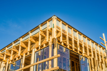 Partially built wooden structure with windows and clear blue sky