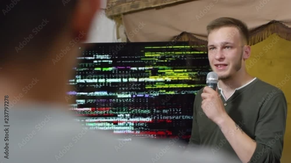 Poster medium shot of two young men delivering presentation at programming seminar and explaining codes dis