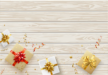 Festive wooden background with top view gifts and colorful confetti.