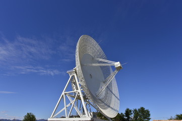 Array of satellite dishes or radio antennas against sky. Space observatory.