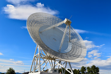 Array of satellite dishes or radio antennas against sky. Space o
