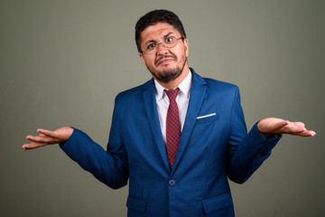 Bearded Persian businessman wearing suit against colored backgro