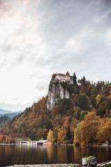 Fototapeta na wymiar Colorful Bled in fall, with the rock top castle in the background. Slovenia