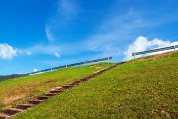 Fototapeta na wymiar Stairway on the meadow with blue sky