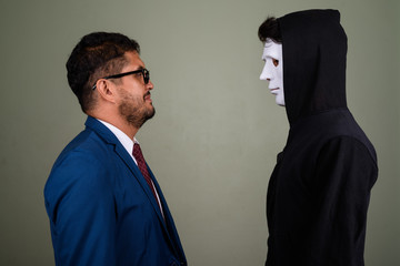 Bearded Persian businessman and young Indian man against colored