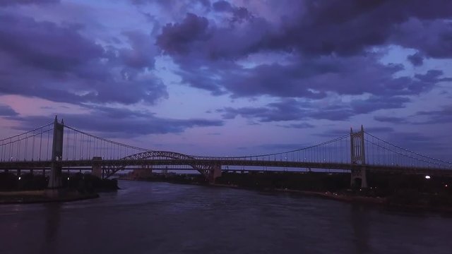 Aerial footage cinematic slow approach on rfk bridge:cloudy canopy sky hells gate bridge