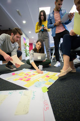 Startup business people in modern office. Group of young business people are working together with laptop. Freelancers sitting on the floor. tech startup, tech team.