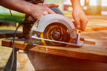 Circular Saw. Carpenter Using Circular Saw for wood beam