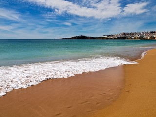 Paradies strand mit feinem roten Sand am tükis farbigen Meer mit Wolken am blauen Himmel