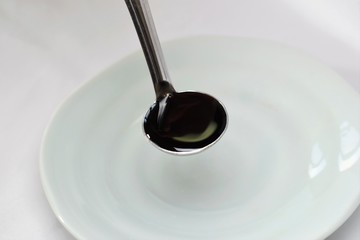 小サジで醤油を計量しているところ