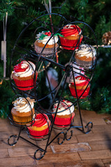 Various colorful Christmas cupcakes with christmas tree on wood table