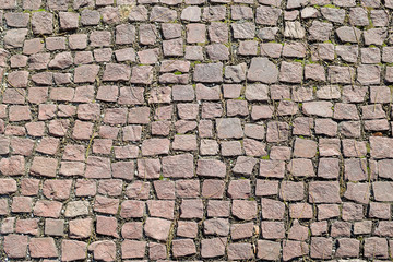 Old cobblestone pavement, paved with reddish stones, historical and architectural texture for background, view from above