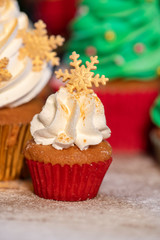 Various colorful Christmas cupcakes with christmas tree on wood table