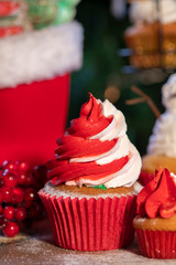 Various colorful Christmas cupcakes with christmas tree on wood table