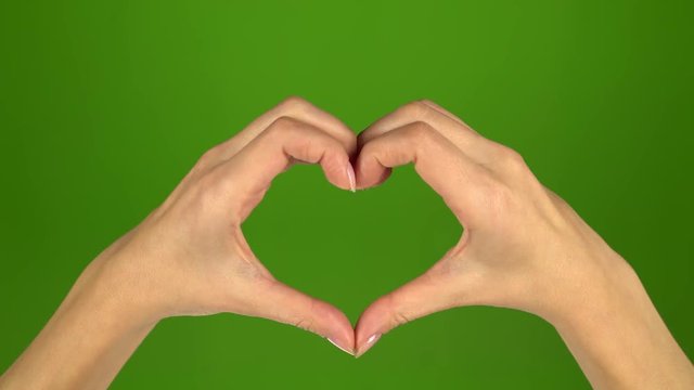 Romantic love sign with hands on green screen