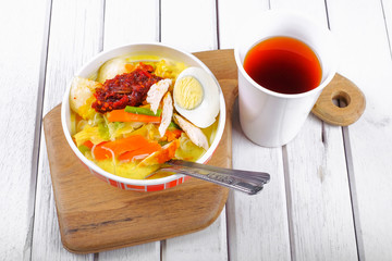 Lontong-Traditional Malaysian and   Indonesian food on wooden table with spoon.