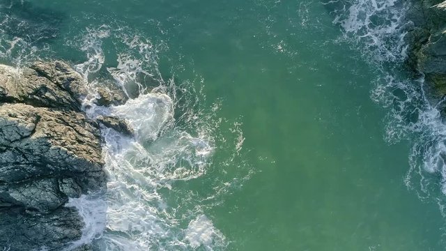 Aerial view approaching land from the sea at Sango Sands, Scotland. The waves batter the rocks below.