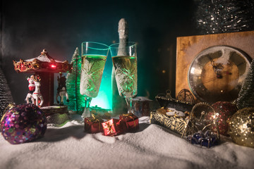 Two glasses of champagne with Christmas decoration. Traditional winter holiday alcohol drink in snow with creative New Year artwork. Copy space.