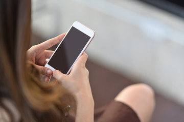 Cropped shot of female hand holding blank screen mobile phone
