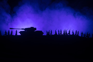 Obraz na płótnie Canvas War Concept. Military silhouettes fighting scene on war fog sky background, World War German Tanks Silhouettes Below Cloudy Skyline At night. Attack scene. Armored vehicles.