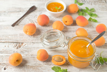 jar with homemade apricot jam on a light wooden background